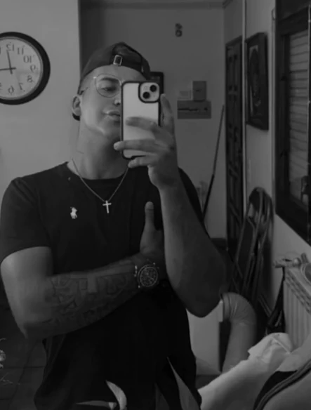 Joan Carbó, el tatuador, con gorra y el brazo tatuado